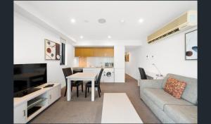 un soggiorno con divano, tavolo e cucina di Hi 5 star Adelaide City Luxury Oasis a Adelaide