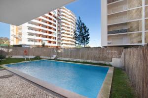 une piscine en face d'un grand bâtiment dans l'établissement Holiday Apartment Portimão, à Portimão
