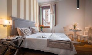 a bedroom with a bed with a table and a window at Boutique Hotel del Corso in Florence