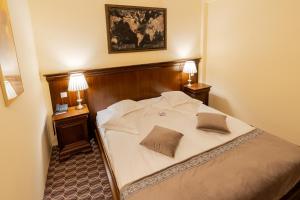 Hotel Dorna في فاترا دورني: غرفة نوم مع سرير مع مواقف ليلتين ومصباحين