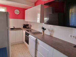 eine Küche mit weißen Schränken und einer roten Wand in der Unterkunft Appartement Cap d'Agde, 3 pièces, 6 personnes - FR-1-607-155 in Cap d'Agde