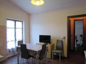 a dining room with a table with chairs and a television at Il Bric in Viola