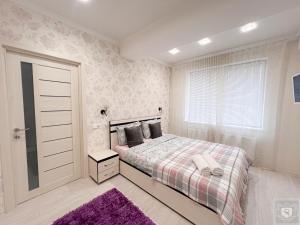 a bedroom with a bed and a purple rug at RentHouse Apartments Deep Purple in Chişinău