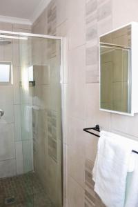a shower with a glass door and a towel at Rental Flat in Maseru in Maseru