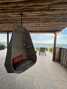 a hammock on a patio with a view of the ocean at Peri-Peri Divers B&B Morrungulo in Cabo Nhabacal