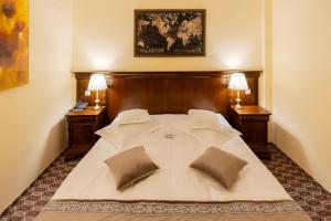 1 dormitorio con 1 cama blanca grande y 2 lámparas en Hotel Dorna, en Vatra Dornei