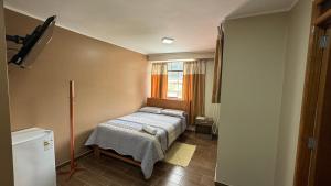 ein kleines Schlafzimmer mit einem Bett und einem Fenster in der Unterkunft Hostal Tinkoj in Chavín de Huantar