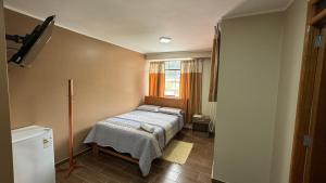 a small bedroom with a bed and a window at Hostal Tinkoj in Chavín de Huantar