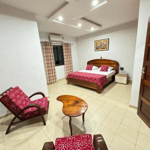 Un dormitorio con una cama, una mesa y una silla. en Lome Bamboo Lodge, en Lomé