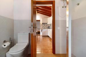a bathroom with a toilet and a kitchen at La Casita de Abuela Paula in Valleseco