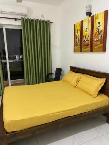 a bedroom with a bed with yellow sheets and a window at Sea view A in Mount Lavinia