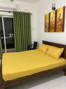 una camera da letto con un letto con lenzuola gialle e una finestra di Sea view A a Mount Lavinia