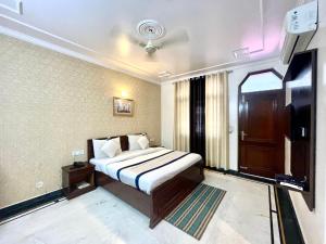 a bedroom with a bed and a tv in a room at Shakuntala heritage Grand in Lucknow