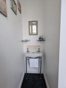 a white bathroom with a sink and a mirror at The Dulwich in Cheltenham