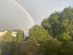 un arco iris en el cielo sobre una ciudad con árboles en The Dulwich, en Cheltenham