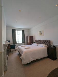 um quarto com uma cama grande e uma janela em The Dulwich em Cheltenham