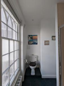 a bathroom with a toilet and a large window at The Dulwich in Cheltenham