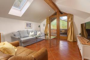 a living room with a couch and a tv at Appartement Berggasse by Schladming-Appartements in Schladming