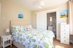 a bedroom with a bed with a white bedspread at Family Beach House 200m to Sea 5 min to Tenby Town Centre in Pembrokeshire