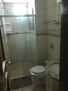 a bathroom with a shower and a toilet and a sink at Vista Inacreditável Por do SOL in Tramandaí