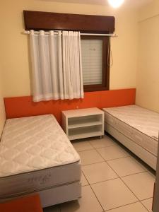 2 Einzelbetten in einem Zimmer mit Fenster in der Unterkunft Vista Inacreditável Por do SOL in Tramandaí