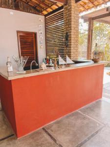een keuken met een oranje eiland in een kamer bij Villa Camboa - Barrinha de baixo - Ceará in Barrinha