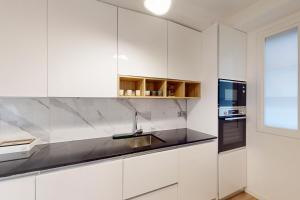 a kitchen with white cabinets and a sink and a window at Loft Victor Hugo 73 Fshh in Nice