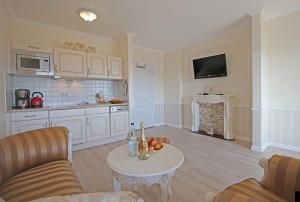ein Wohnzimmer mit einem Tisch und einer Küche in der Unterkunft Villa Katharina in Sassnitz