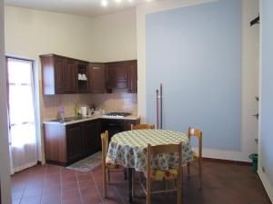 eine Küche mit einem Tisch und Stühlen sowie eine Küche mit einem Kühlschrank in der Unterkunft Il Bric in Viola