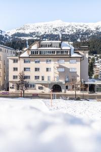 a building with snow in front of it at Hotel Lenzerhorn in Lenzerheide