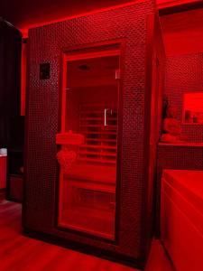 Habitación roja con ducha y espejo. en Pause Thermale, en Herstal