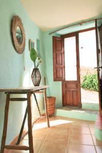 Cette chambre dispose d'une table en bois et d'une porte. dans l'établissement La Casita del Chopo by SIERRA VIVA, à Cortelazor