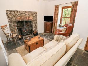 a living room with a couch and a fireplace at Hillside Holiday Cottage in Treorky