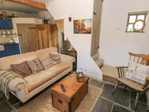 a living room with a couch and a table at Hillside Holiday Cottage in Treorky