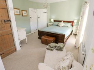 a small bedroom with a bed and a couch at Hillside Holiday Cottage in Treorky