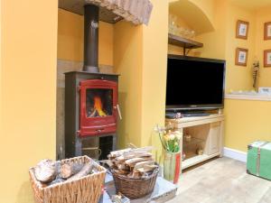 a living room with a wood stove in a room at Yew Tree Cottage in Chesterfield