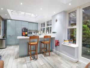 a kitchen with two stools at a kitchen island at Yew Tree Cottage in Chesterfield