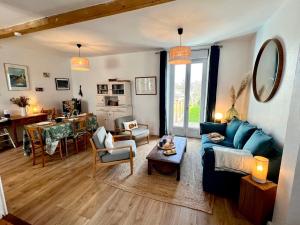- un salon avec un canapé bleu et une table dans l'établissement Ker-Jeannette, familiale, chaleureuse, plages à 2 km, à Clohars-Carnoët