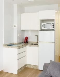 - une cuisine blanche avec des placards blancs et un four micro-ondes dans l'établissement 1 Hab, Confort 4 plazas a 180m Playa, PlazamarCentro 2, à Torre del Mar