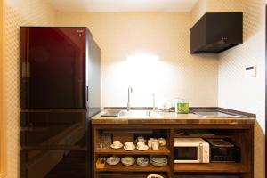 a kitchen with a sink and a microwave at 静響の宿 Silent Echo Inn in Osaka