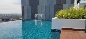 a swimming pool with a fountain on the side of a building at Horizon Delux Suite @ Ipoh Town in Ipoh