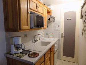 a kitchen with a sink and a coffee maker on a counter at La Palmyre - CHARMANTE VILLA MITOYENNE avec TERRASSE CLOSE in Les Mathes