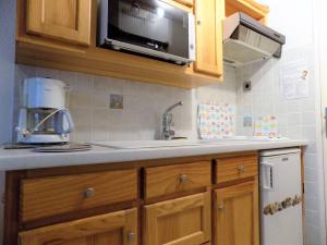 eine Küche mit einer Spüle und einer Mikrowelle in der Unterkunft La Palmyre - CHARMANTE VILLA MITOYENNE avec TERRASSE CLOSE in Les Mathes