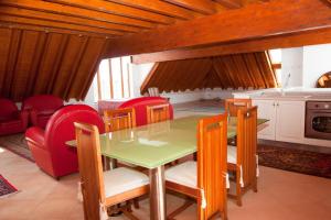 a dining room with a green table and red chairs at Villa Strampelli in Pomezia
