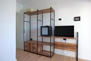 Habitación con TV y estante con TV. en Edva Resort en Vlorë