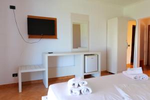 a room with two beds and a desk and a tv at Edva Resort in Vlorë