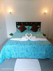 un lit bleu avec deux cygnes dessus dans l'établissement Funky Crab The River, à Krabi