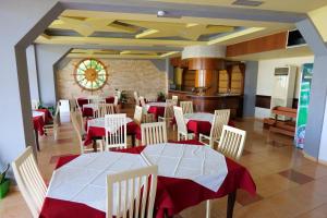 un comedor con mesas y sillas rojas y blancas en Edva Resort en Vlorë