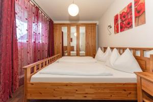 シュラートミンクにあるAppartement Lange Gasse by Schladming-Appartementsのベッドルーム1室(白いシーツが備わる木製ベッド1台付)