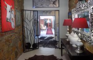Zimmer mit einem Flur und einer Tür mit einem Spiegel in der Unterkunft Barrydale Karoo Lodge - Boutique Hotel in Barrydale